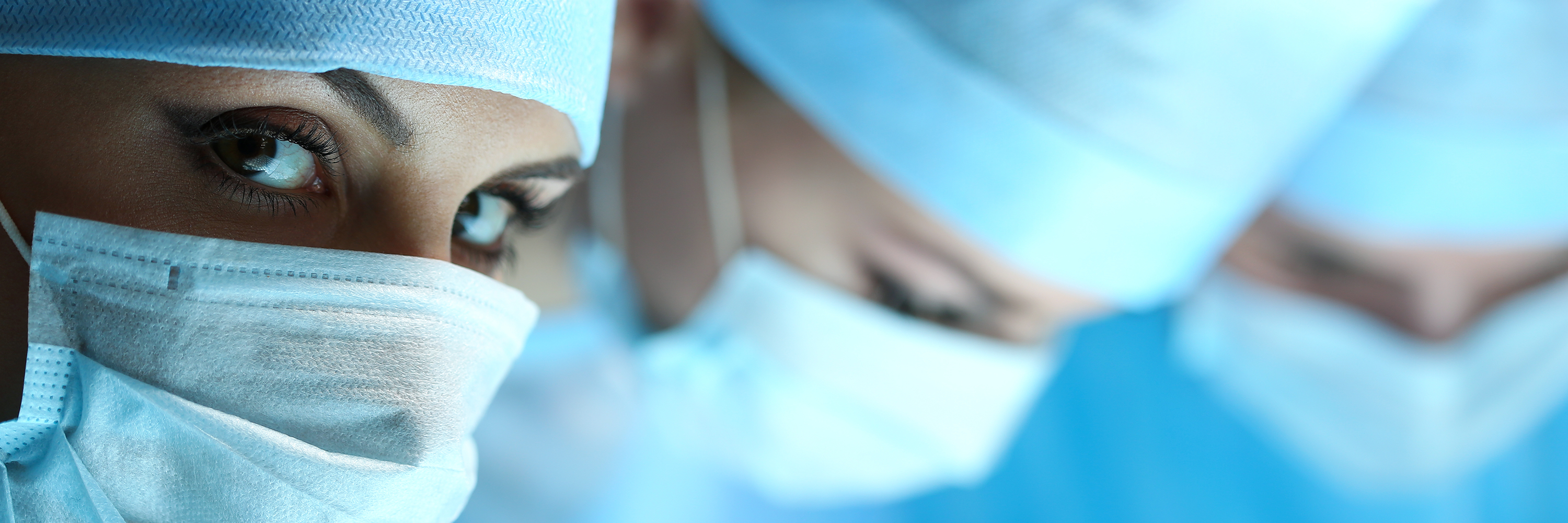 Portrait of a woman with head and mouth protection in an operating theatre in sectional view