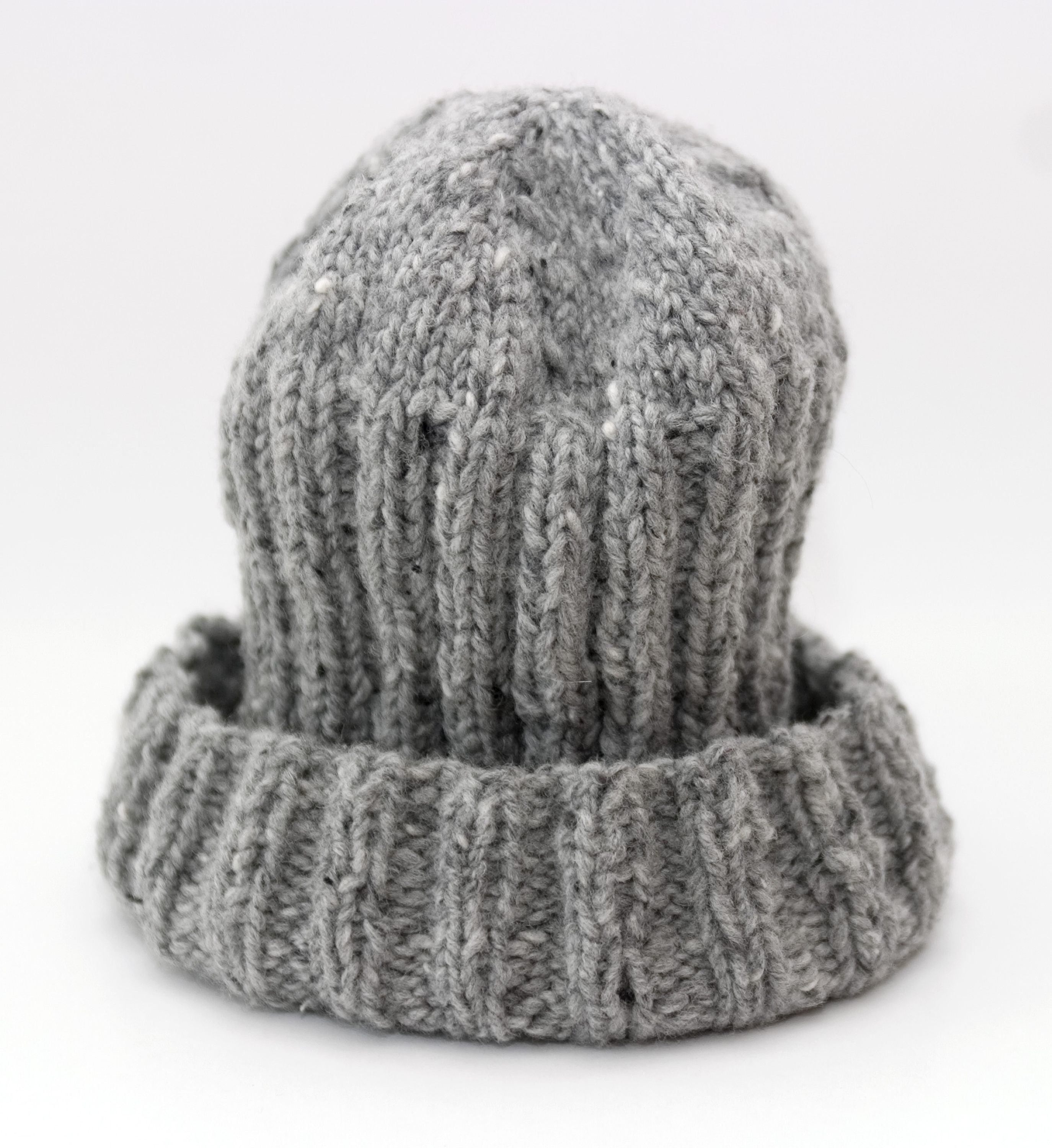 Grey bobble head made of wool with brim as a symbol for the foreskin of the penis